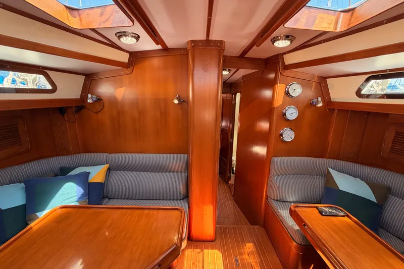 Slide: The Image of Luxurious 2005 Tayana 48 yacht interior with polished wood finish and cozy seating area. - 56