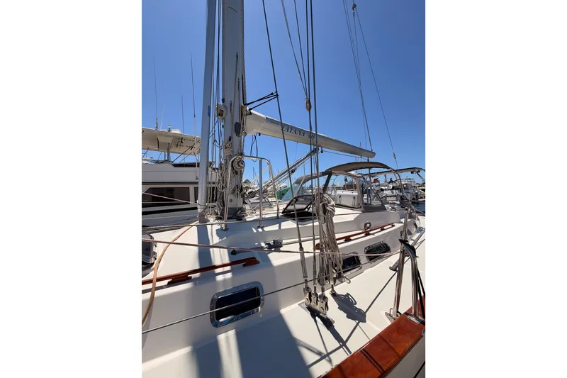 Slide: The Image of 2005 Tayana 48 sailboat docked, showcasing mast and rigging under clear blue sky. - 5