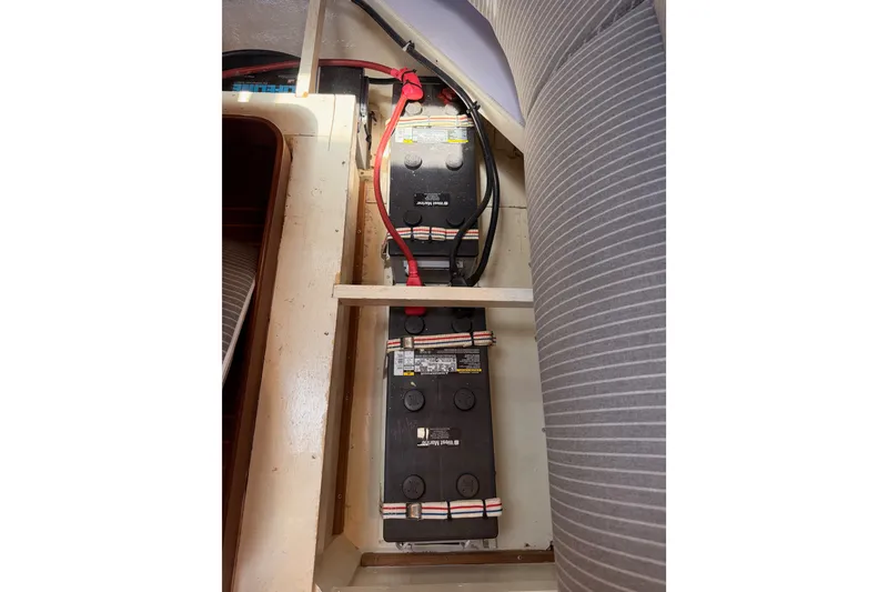 Slide: The Image of Battery compartment of a 2005 Tayana 48 yacht, featuring secured batteries and wiring. - 119