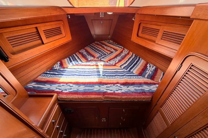 Slide: The Image of Cozy cabin interior of 2005 Tayana 48 yacht with striped bedding and wooden finish. - 67