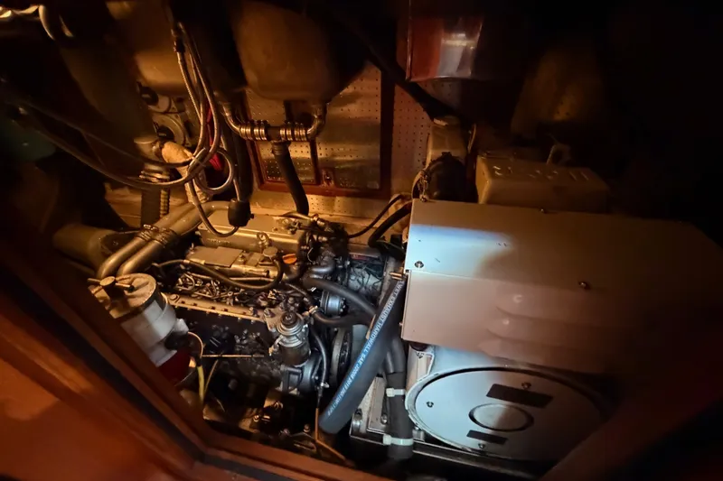 Slide: The Image of Engine room of a 2005 Tayana 48 yacht, showcasing mechanical components and wiring. - 116