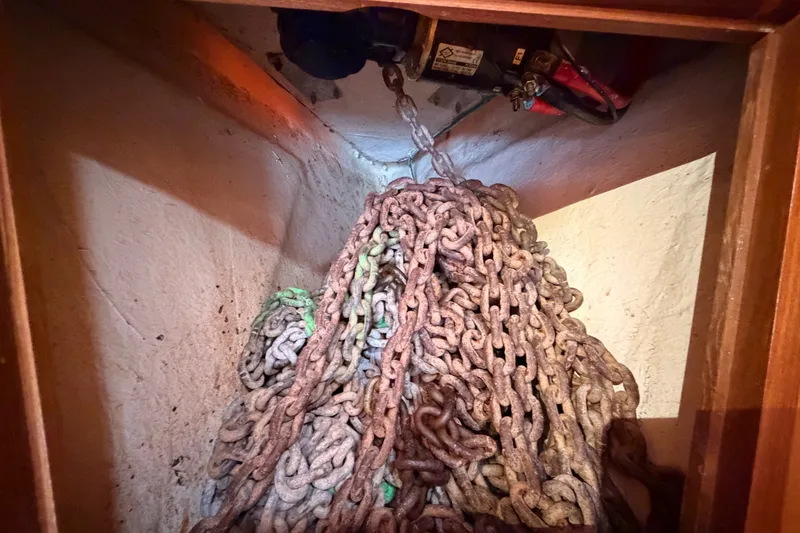 Slide: The Image of Anchor chain storage in a 2005 Tayana 48 sailboat, showcasing rusted metal links. - 72