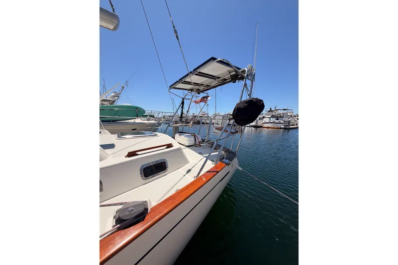 Slide: The Image of 2005 Tayana 48 sailboat docked in marina, featuring sleek design and clear blue sky. - 8