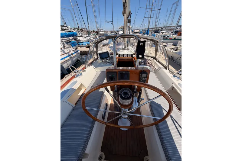 Slide: The Image of Cockpit view of 2005 Tayana 48 sailboat with wooden steering wheel and navigation instruments. - 33