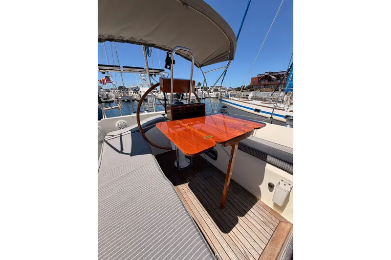 Slide: The Image of Cockpit of 2005 Tayana 48 sailboat with wooden table and helm, docked at marina. - 38