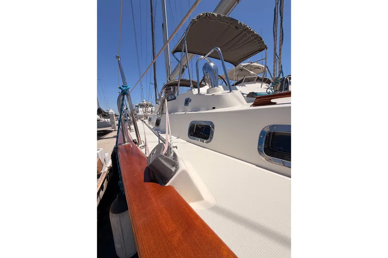 Slide: The Image of 2005 Tayana 48 sailboat deck with polished wood and stainless steel fittings. - 11