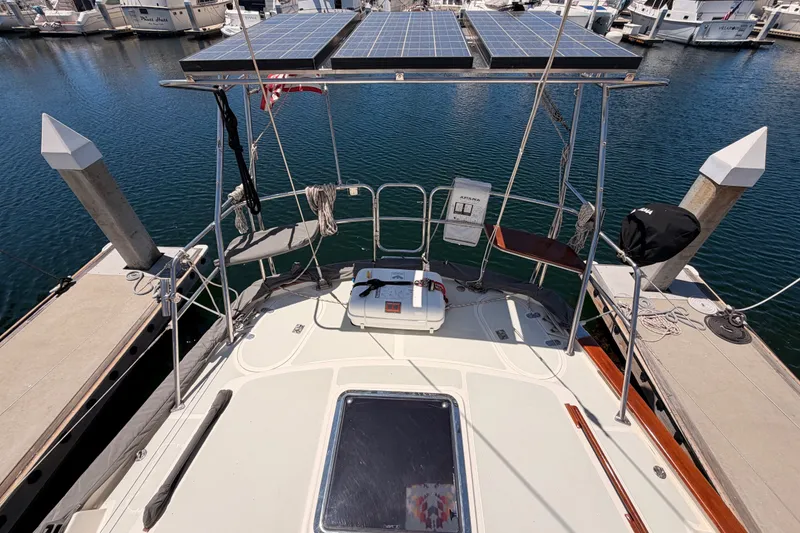 Slide: The Image of Tayana 48 sailboat from 2005 docked, featuring solar panels and a spacious deck. - 26