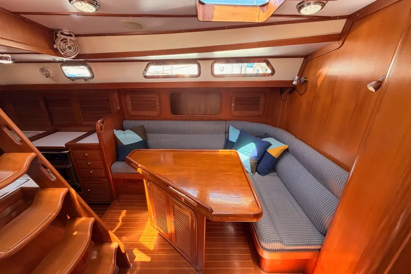 Slide: The Image of Cozy interior of 2005 Tayana 48 yacht with wooden furnishings and striped seating. - 55