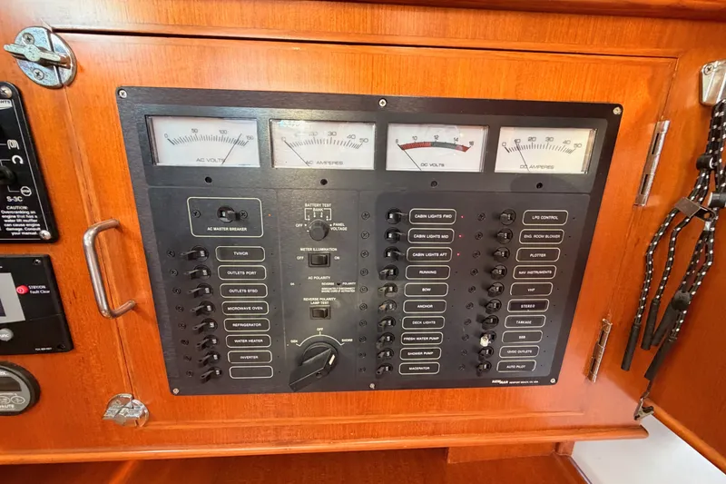 Slide: The Image of Electrical control panel on a 2005 Tayana 48 yacht, featuring various switches and gauges. - 51