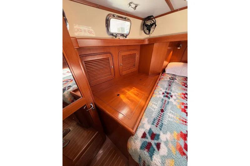 Slide: The Image of Cozy cabin interior of 2005 Tayana 48 yacht with colorful bedding and wooden finish. - 88