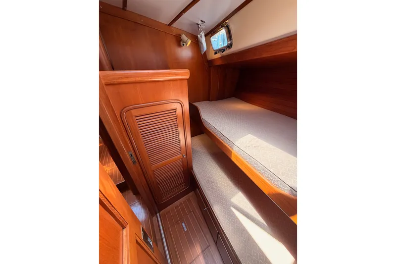 Slide: The Image of Interior of 2005 Tayana 48 yacht with wooden bunk beds and porthole. - 65