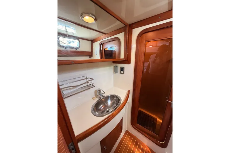 Slide: The Image of Luxurious 2005 Tayana 48 yacht bathroom with wooden accents and stainless steel sink. - 90