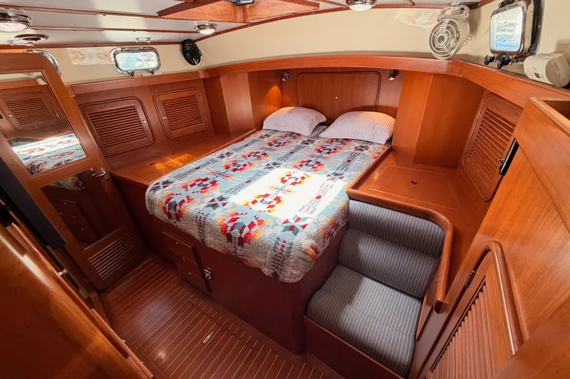 Slide: The Image of Luxurious 2005 Tayana 48 yacht cabin with cozy bed and wooden interior. - 84