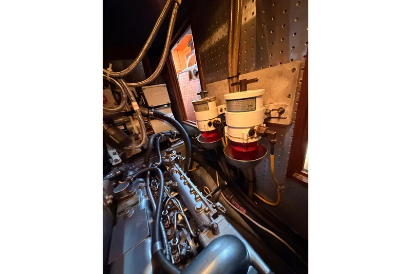 Slide: The Image of Engine room of a 2005 Tayana 48 yacht, showcasing mechanical components and filters. - 110