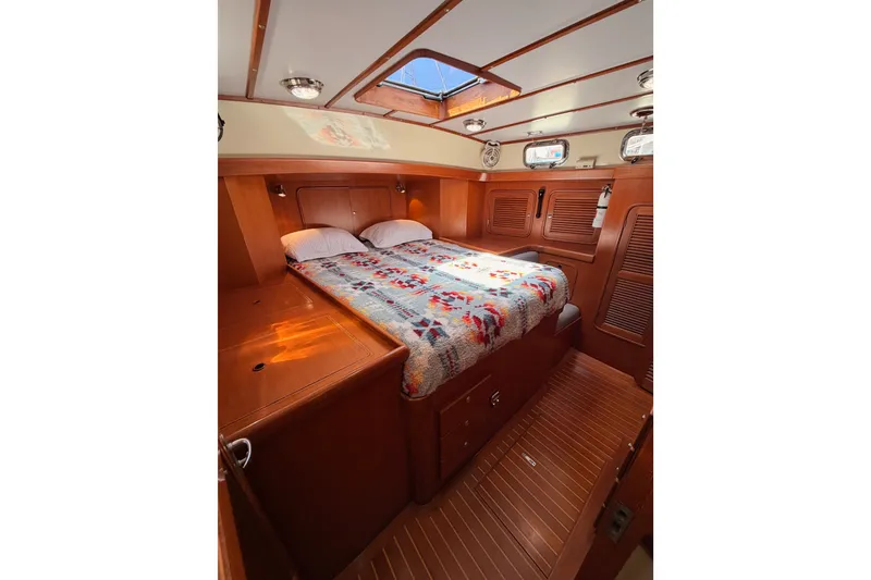 Slide: The Image of Luxurious 2005 Tayana 48 yacht cabin with cozy bed and elegant wood finish. - 95