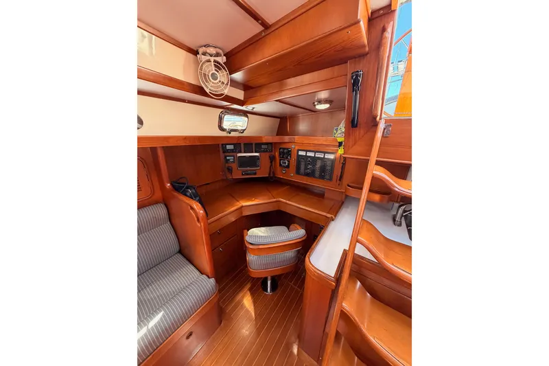Slide: The Image of 2005 Tayana 48 yacht interior with navigation station and wooden cabinetry. - 49