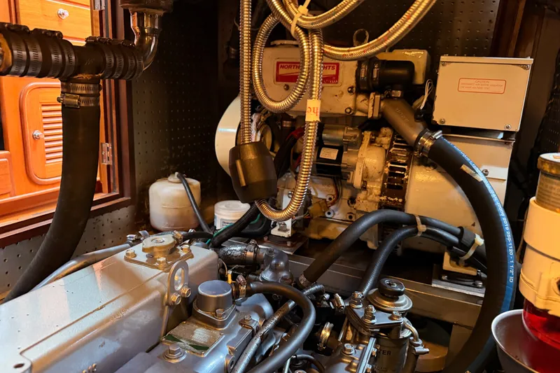 Slide: The Image of Engine room of a 2005 Tayana 48 yacht, showcasing mechanical components and hoses. - 109