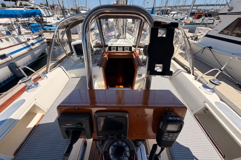 Slide: The Image of Cockpit view of 2005 Tayana 48 sailboat with navigation equipment and marina background. - 34