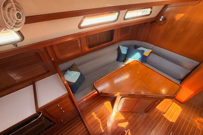 Slide: The Image of Cozy interior of 2005 Tayana 48 yacht with wooden table and cushioned seating. - 46