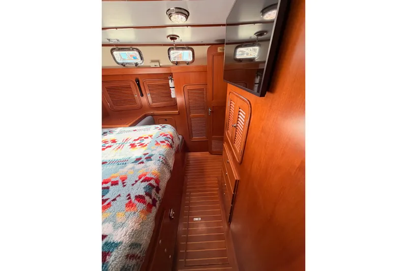 Slide: The Image of Cozy cabin interior of 2005 Tayana 48 yacht with wooden finishes and colorful bedding. - 96