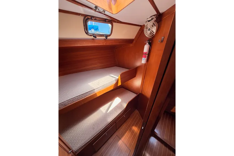 Slide: The Image of Interior of 2005 Tayana 48 yacht with wooden bunk beds and a porthole. - 64