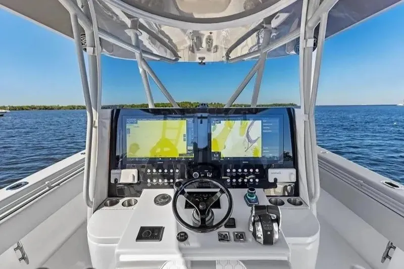 Slide: The Image of 2022 Contender 44 CB boat cockpit with advanced navigation displays on open water. - 15