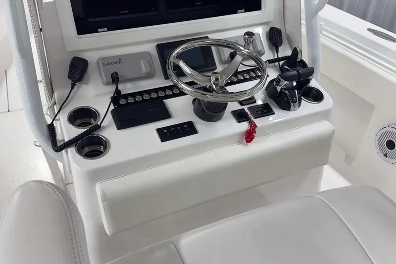 Slide: The Image of 2022 Contender 32 ST boat console with steering wheel, controls, and Garmin electronics. - 2