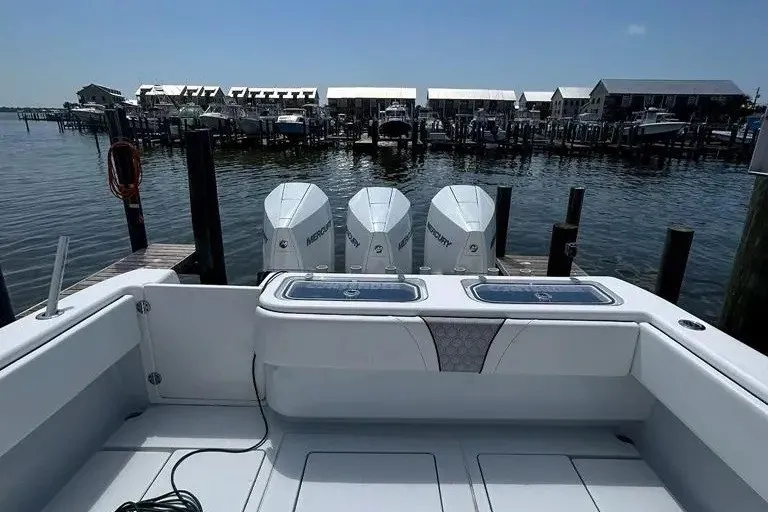 Slide: The Image of 2021 Contender 35 ST boat with triple Mercury engines docked at a marina. - 7
