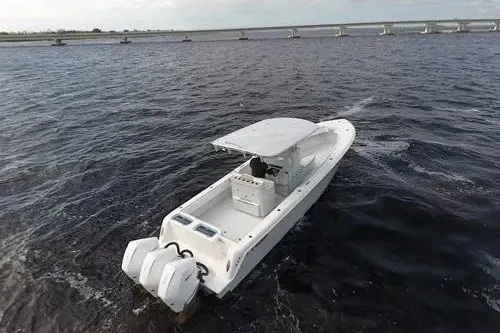 Slide: The Image of 2021 Contender 35 ST boat cruising on open water near a bridge. - 3