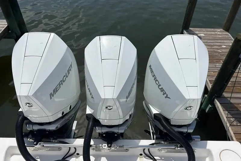 Slide: The Image of Triple Mercury outboard engines on a 2021 Contender 35 ST boat at a dock. - 4