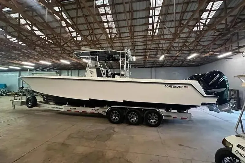 Slide: The Image of 2019 Contender 39 ST boat on trailer in warehouse, side view. - 2