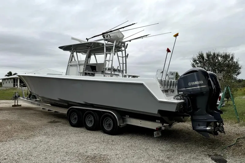 Slide: The Image of 2014 Contender 39 ST boat with Yamaha engines on a trailer, parked outdoors. - 14