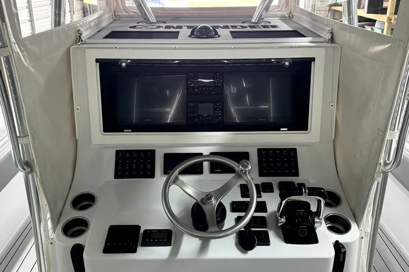 Slide: The Image of 2014 Contender 39 ST boat helm with steering wheel and navigation controls. - 23