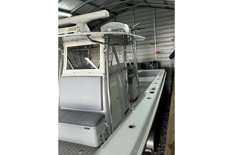 Slide: The Image of 2014 Contender 39 ST boat in a metal storage shed, showcasing sleek design and seating. - 24