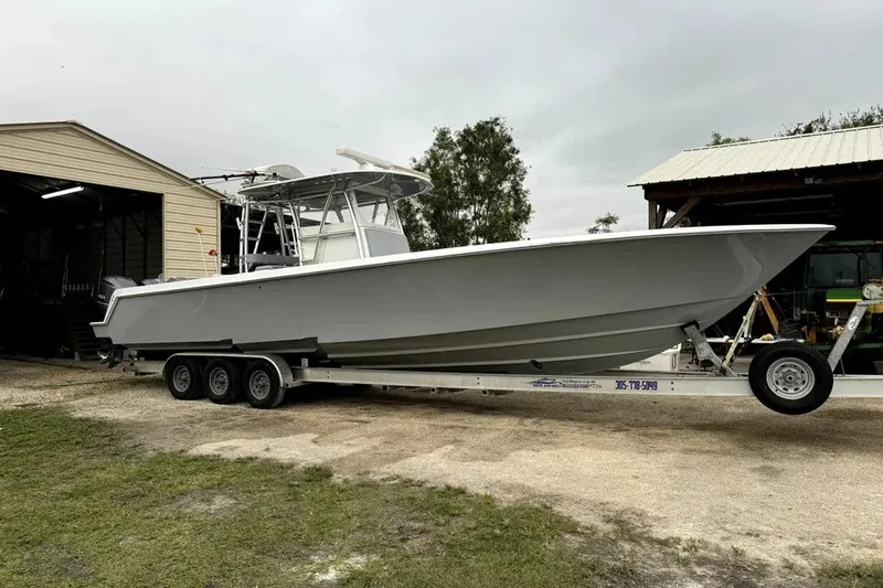 Slide: The Image of 2014 Contender 39 ST boat on trailer near storage buildings. - 15