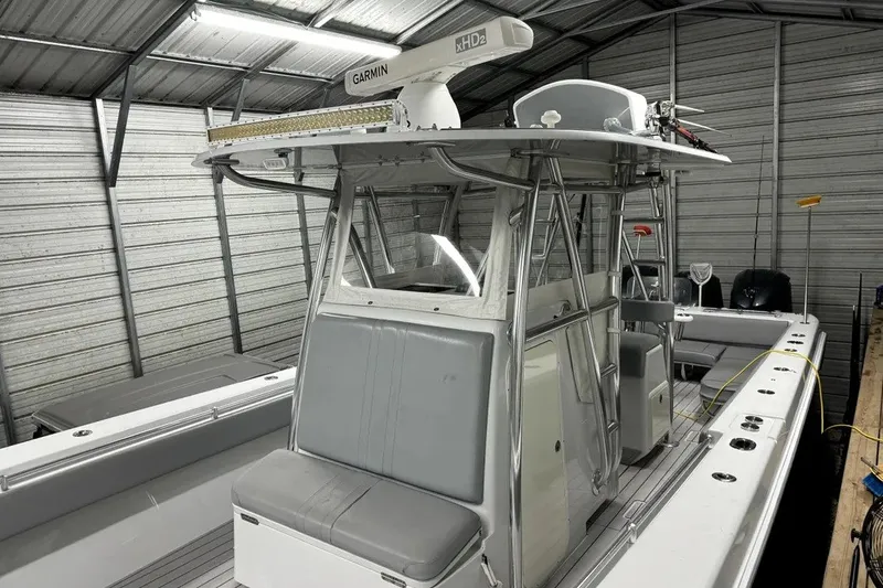 Slide: The Image of 2014 Contender 39 ST boat in storage, featuring Garmin radar and sleek seating. - 16