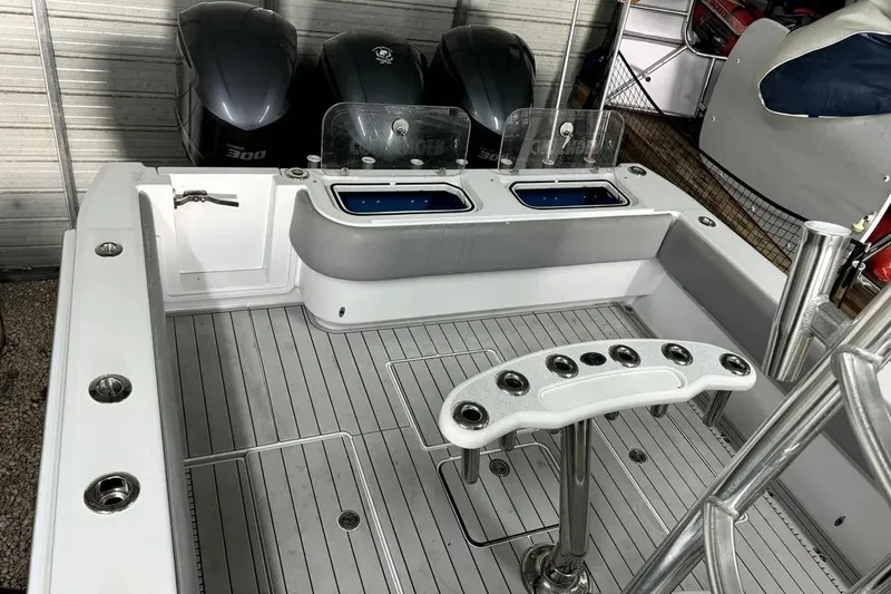 Slide: The Image of 2014 Contender 39 ST boat deck with fishing rod holders and triple outboard engines. - 19