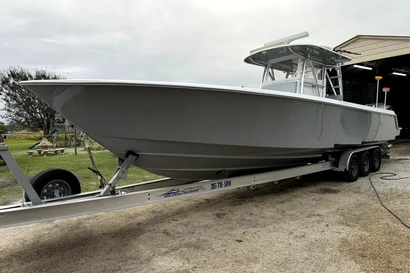 Slide: The Image of 2014 Contender 39 ST boat on trailer, parked outdoors near a building. - 25