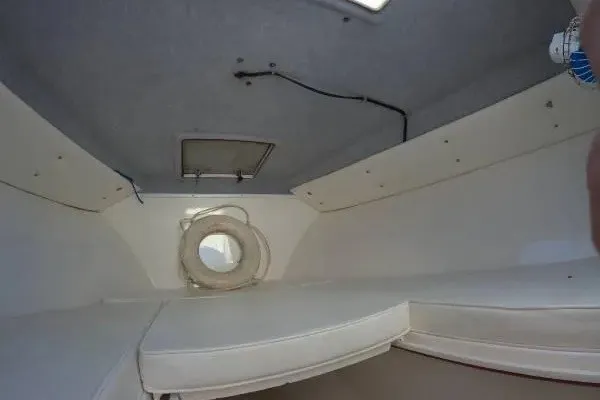 Slide: The Image of Interior cabin of a 1999 Contender 28 Sport boat, featuring cushioned seating and storage space. - 9