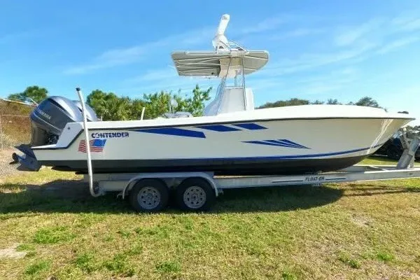 Slide: The Image of 1999 Contender 28 Sport boat on trailer, side view, outdoors under clear sky. - 15