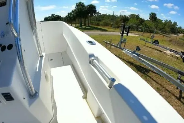 Slide: The Image of 1999 Contender 28 Sport boat deck with railing, parked on grassy area under blue sky. - 13
