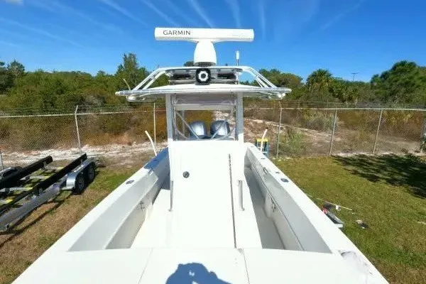Slide: The Image of 1999 Contender 28 Sport boat with Garmin radar, parked on grass near a fence. - 8