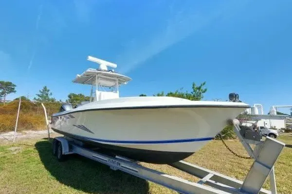 Slide: The Image of 1999 Contender 28 Sport boat on trailer under clear blue sky. - 2