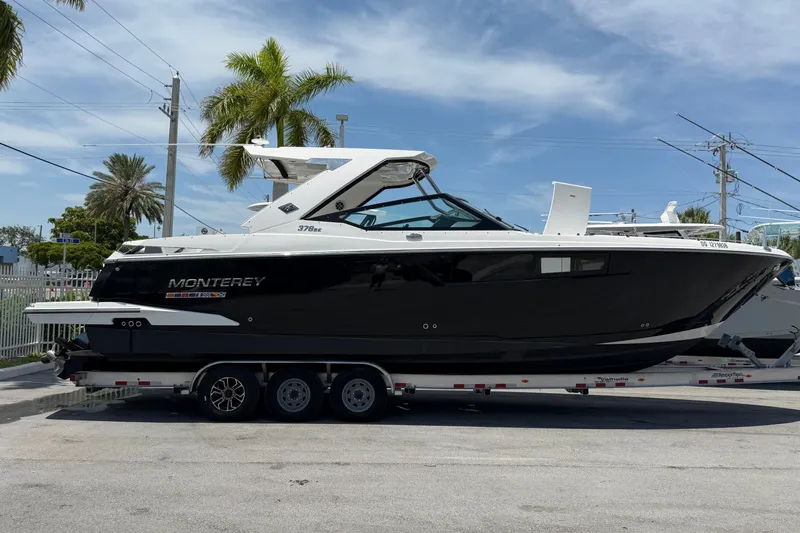 The Image of 2018 Monterey 378SE Super Express boat on trailer, parked under clear blue sky. - 0