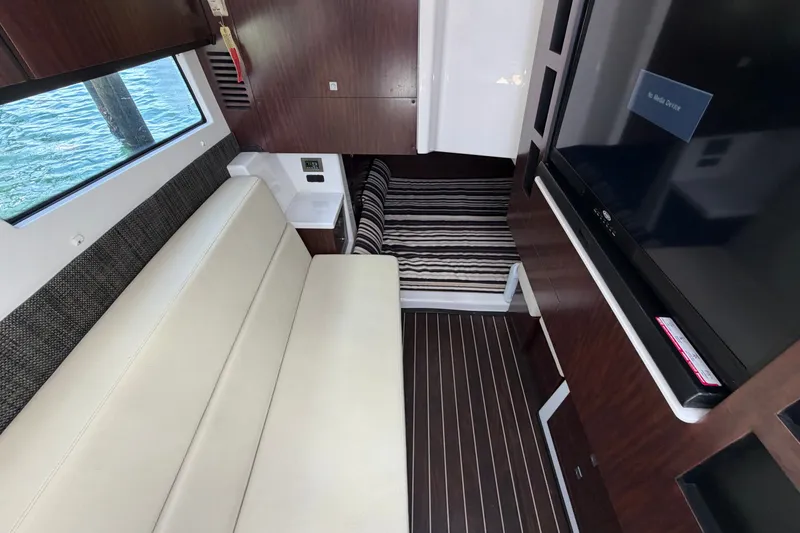 Slide: The Image of Interior of a 2018 Monterey 378SE Super Express boat with seating and a TV. - 20