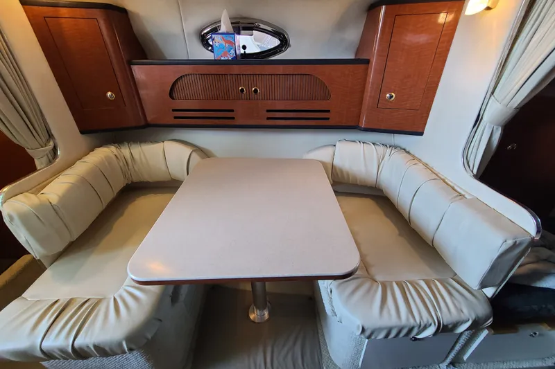 Slide: The Image of Interior of 2004 Sea Ray Sundancer 280 with cozy dining area and cushioned seating. - 4