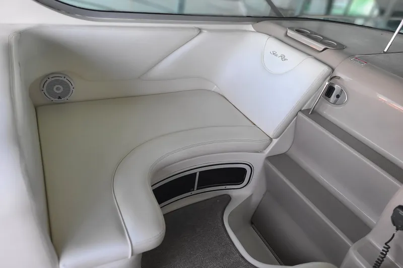 Slide: The Image of Interior seating of 2004 Sea Ray Sundancer 280 boat, featuring white upholstery and built-in speaker. - 9