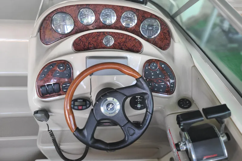 Slide: The Image of Dashboard of a 2004 Sea Ray Sundancer 280 boat with wood accents and steering wheel. - 10