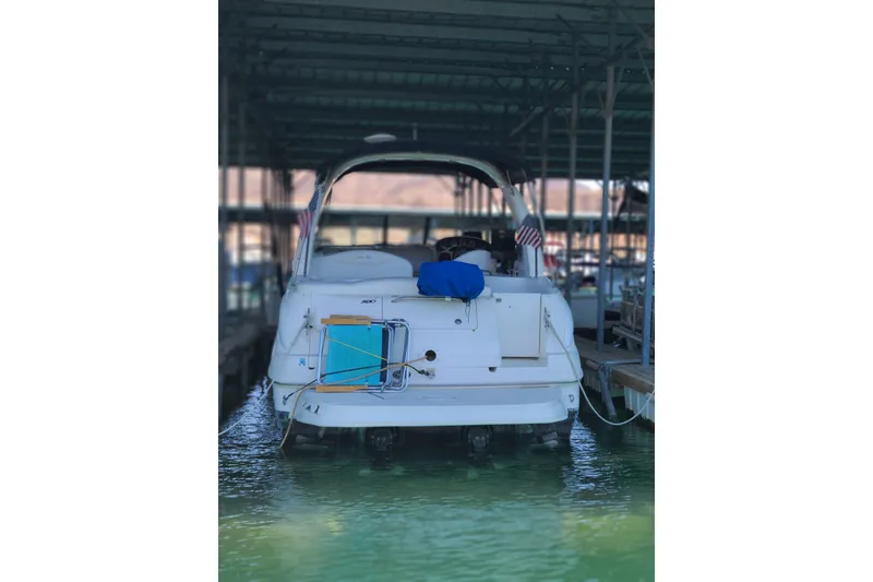 Slide: The Image of 2004 Sea Ray Sundancer 280 docked in a marina, rear view with American flags. - 3