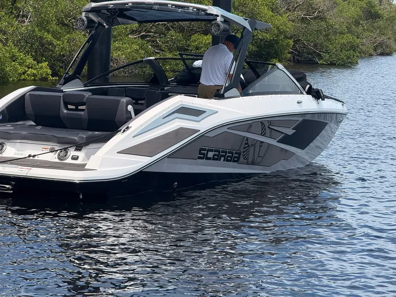 Slide: The Image of A modern 2026 Scarab 285 LX on calm water, featuring sleek design and spacious deck. - 2
